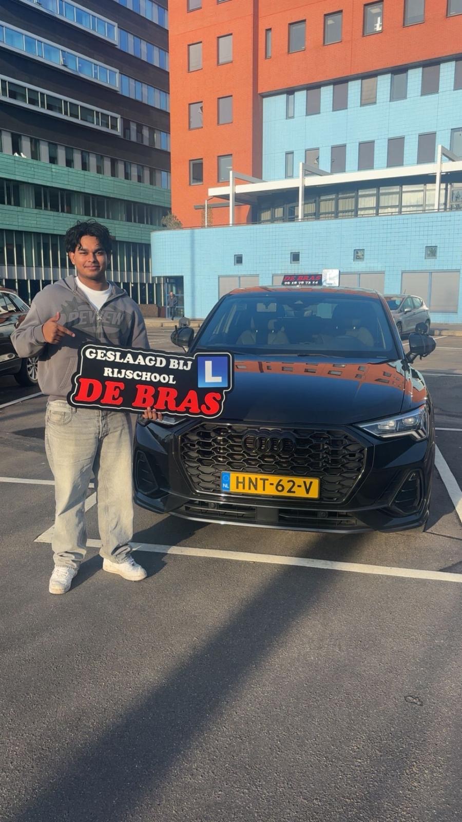 Geslaagde leerling van Rijschool De Bras bij de lesauto